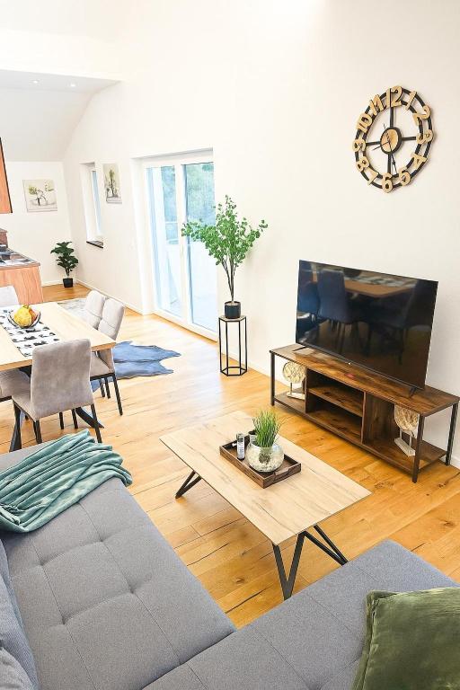 a living room with a couch and a flat screen tv at Stylische Ferienwohnung in Salzburg