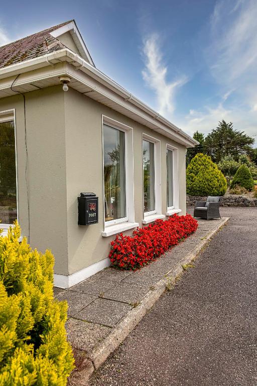 a house with red flowers on the side of it at Fernfeild in Old Twopothouse Cross Roads