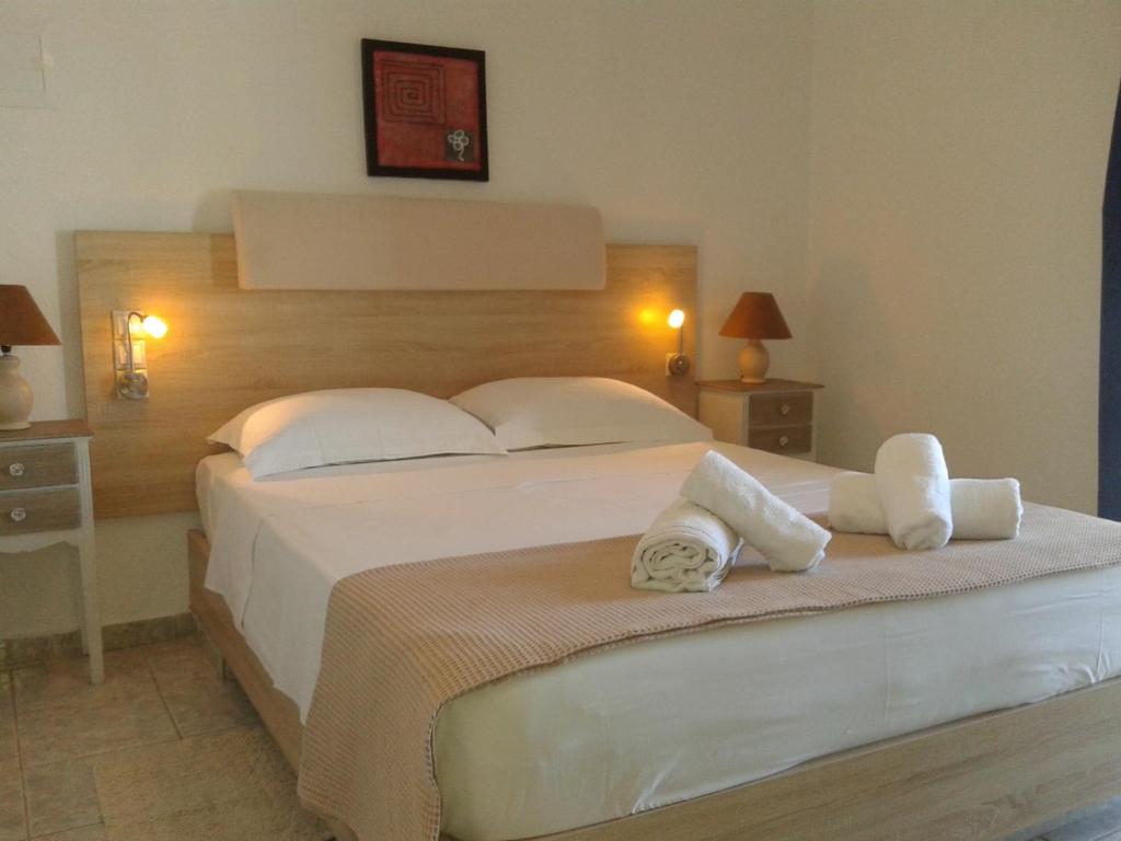 a bedroom with a large white bed with towels on it at Hotel Petras Beach in Sitia