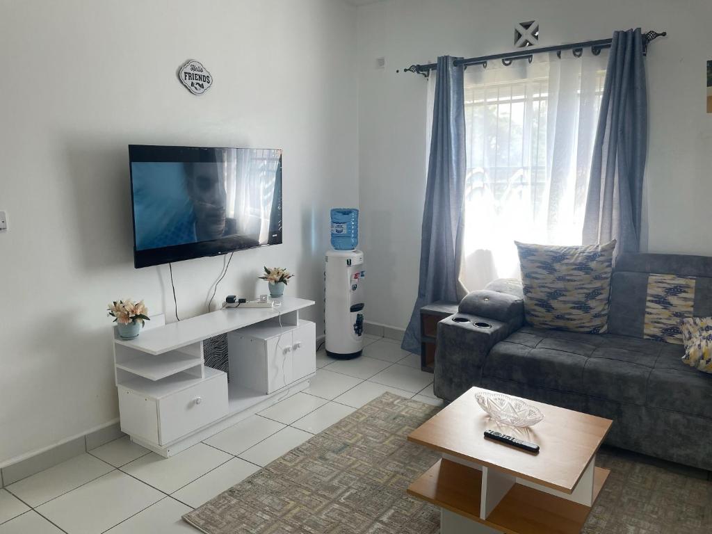 モンバサにあるZunaya Homesのソファと薄型テレビのあるリビングルーム