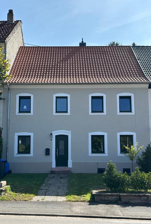 a white house with a red roof at Maison de Chasse Karlsbrunn in Großrosseln