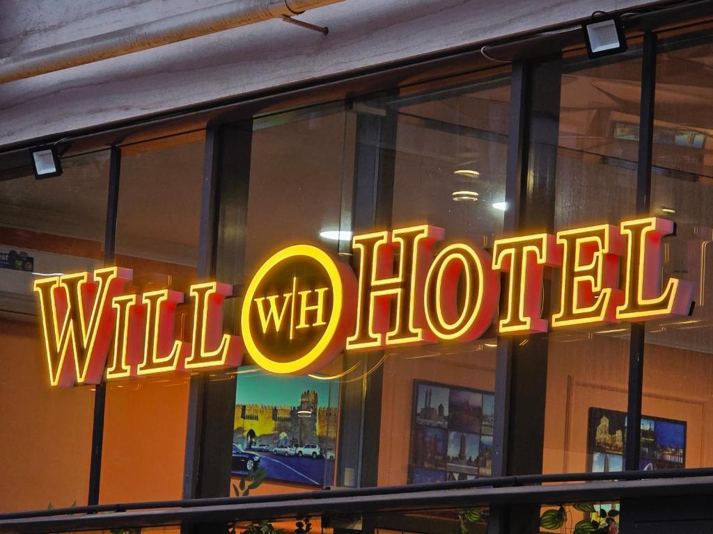 a neon sign in the window of a restaurant at Will Hotel in Baku