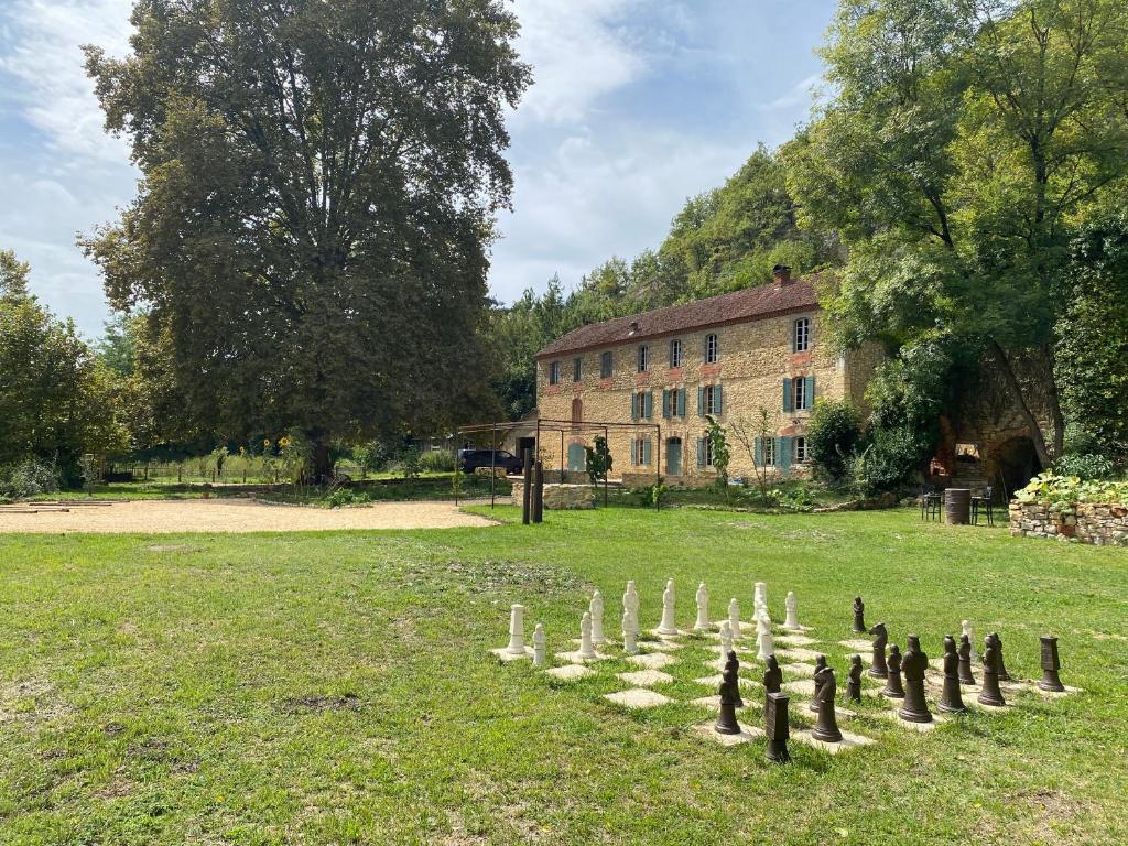 a game of chess in a field in front of a building at Maison as Cambous in Sauveterre-la-Lémance