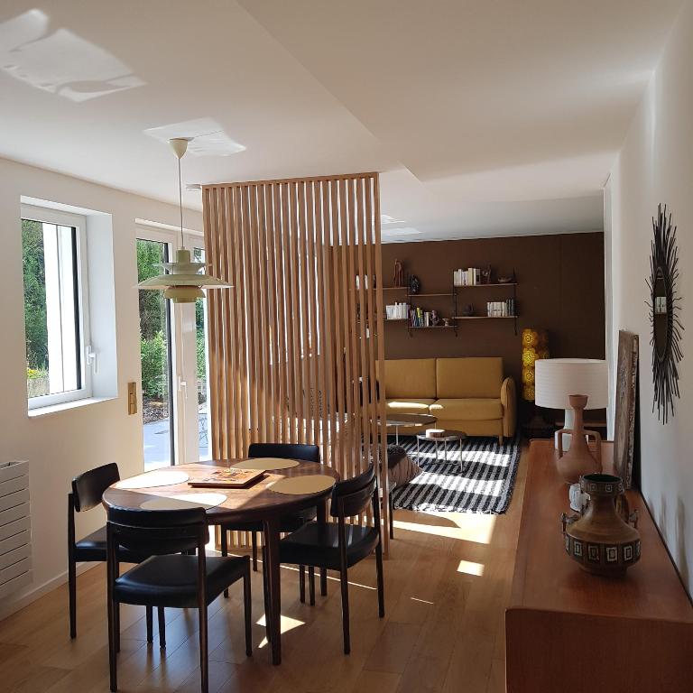 a living room with a dining room table and chairs at gite O repaire de la corniche in Obernai