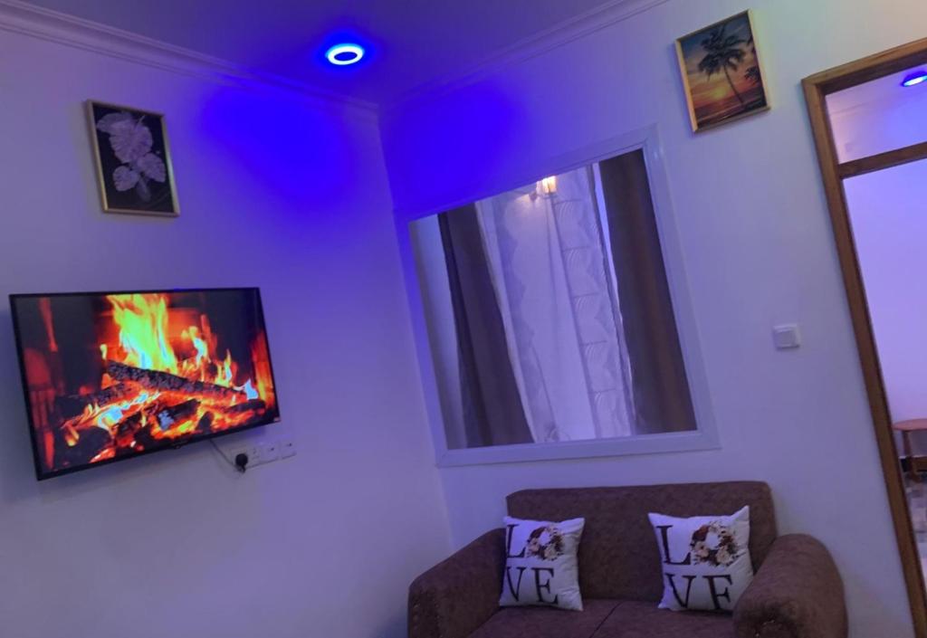 a living room with a fireplace and a tv on the wall at Freetime zone in Dar es Salaam