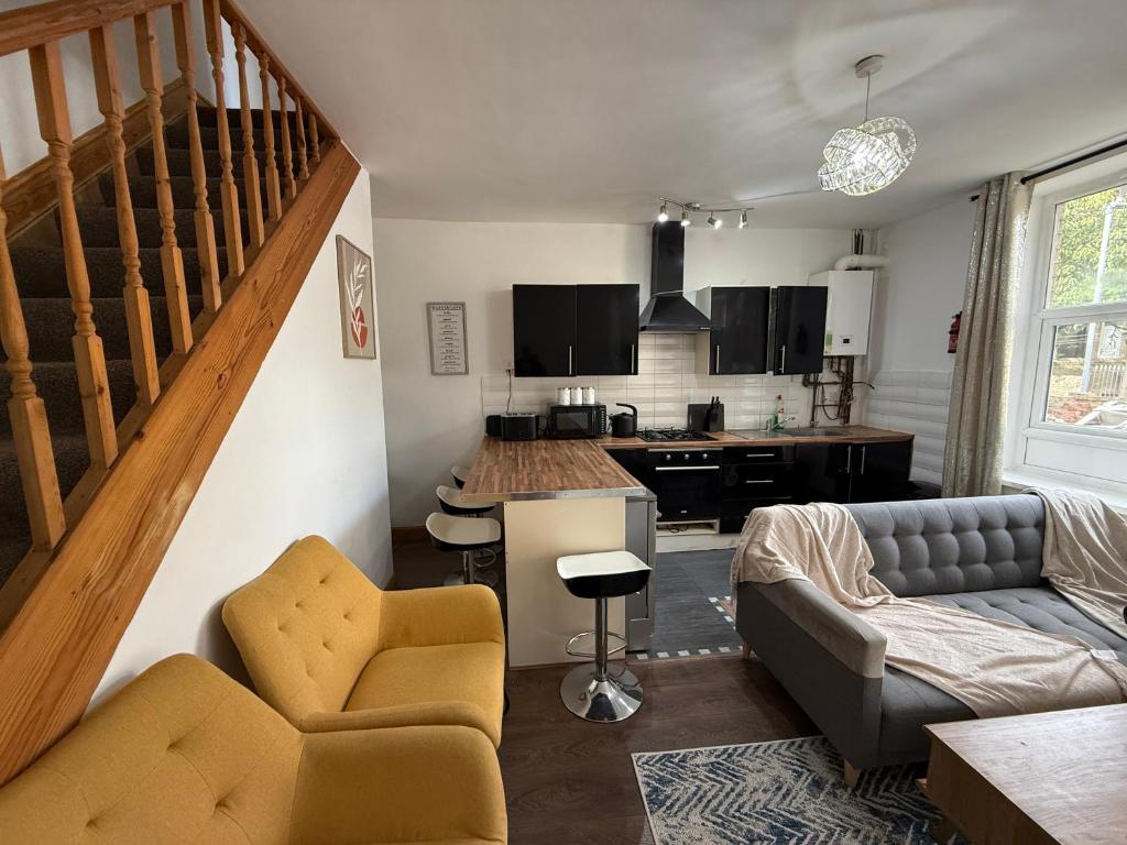 a living room with a couch and a kitchen at Bradford Serviced Accommodation - Apartments - 2 Bed House-Close To Centre - Hospital - Contractors - Business Travellers - Families in Bradford