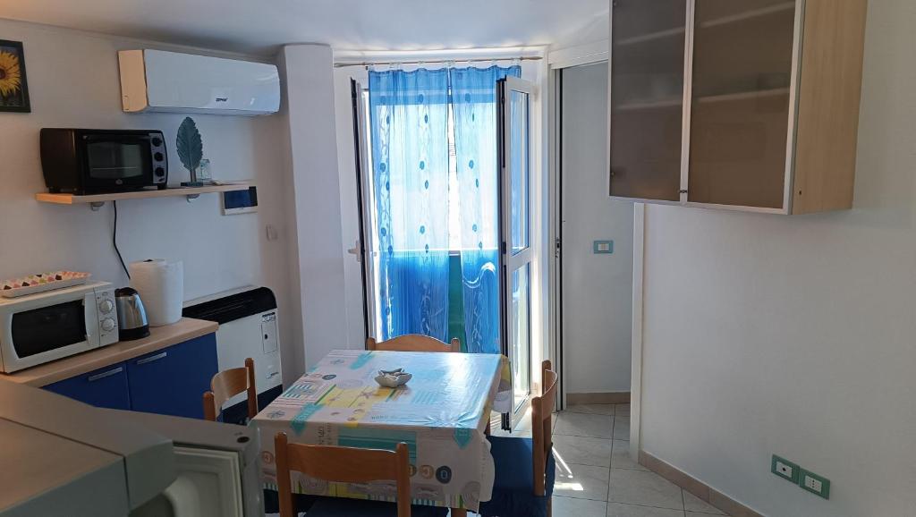a small kitchen with a table and a window at Estensi 14 in Lido degli Estensi