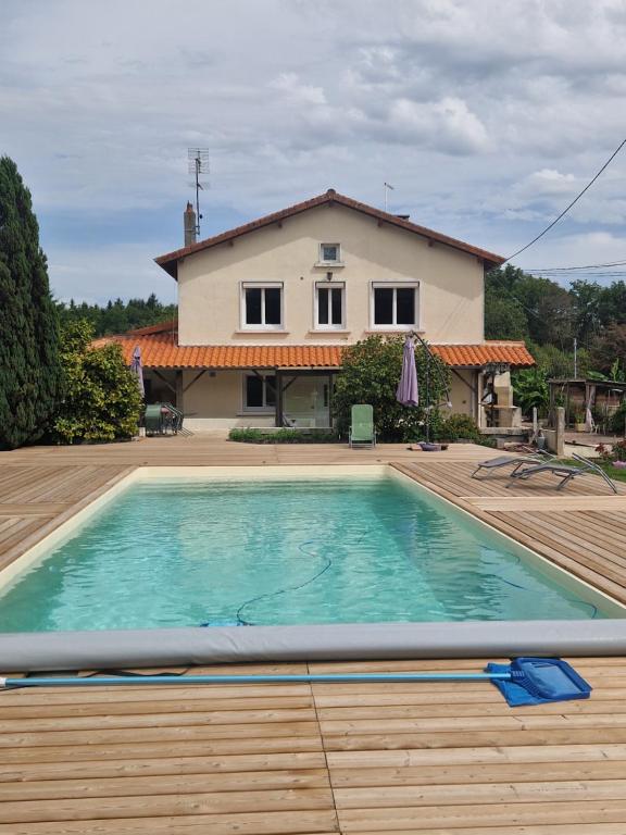 a swimming pool in front of a house at Gîte des chardreaux in Marval