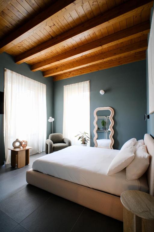 a bedroom with a large bed with a wooden ceiling at The Tower Premium Apartment - Beams & Views - 3 Min Walk to Bernina Express & Station in Tirano