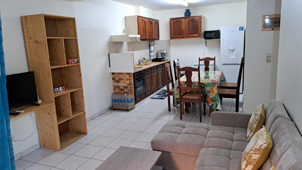 a living room with a couch and a kitchen at Mandariniers 97232-3 in Le Lamentin