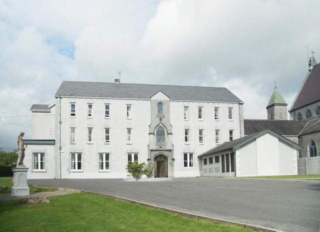 a large white building with a street in front of it at IEC Campus for Groups in Kanturk