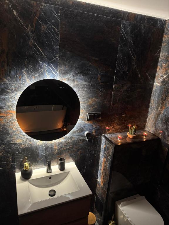 a bathroom with a sink and a mirror at Szmer Olzy Apartament in Istebna