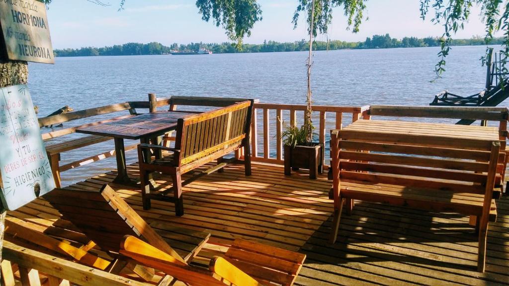 a wooden deck with two benches and a table at casa alpina Maxi premiun in Tigre