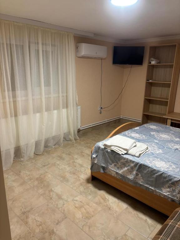 a bedroom with a bed and a flat screen tv at Hotel Giurgiulești in Giurgiuleşti