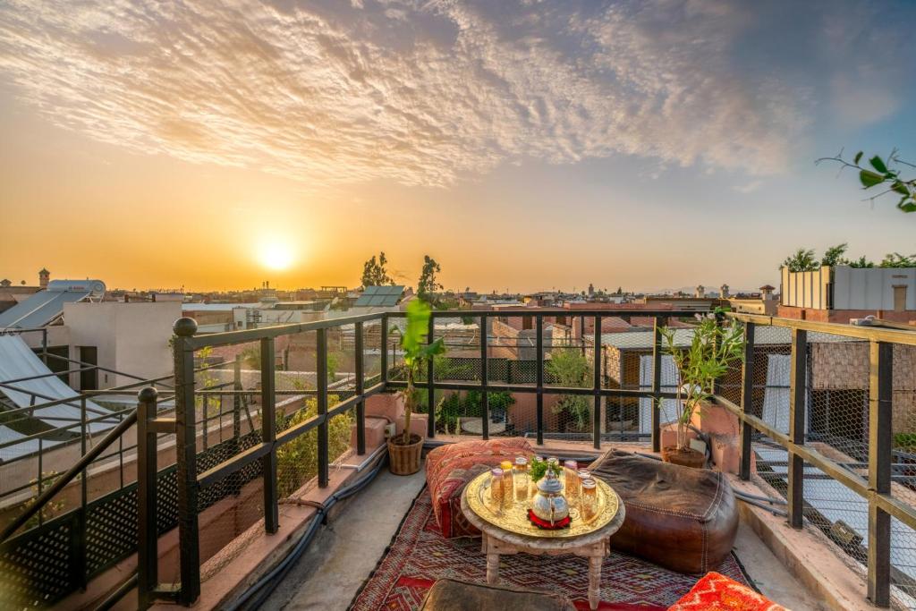 einen Balkon mit einem Tisch und Stadtblick in der Unterkunft Riad Saba in Marrakesch