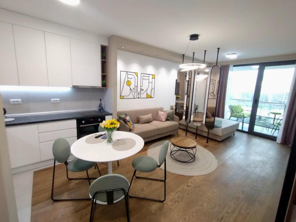 a kitchen and a living room with a table and chairs at Urban Elegance Studio & SPA in Niš
