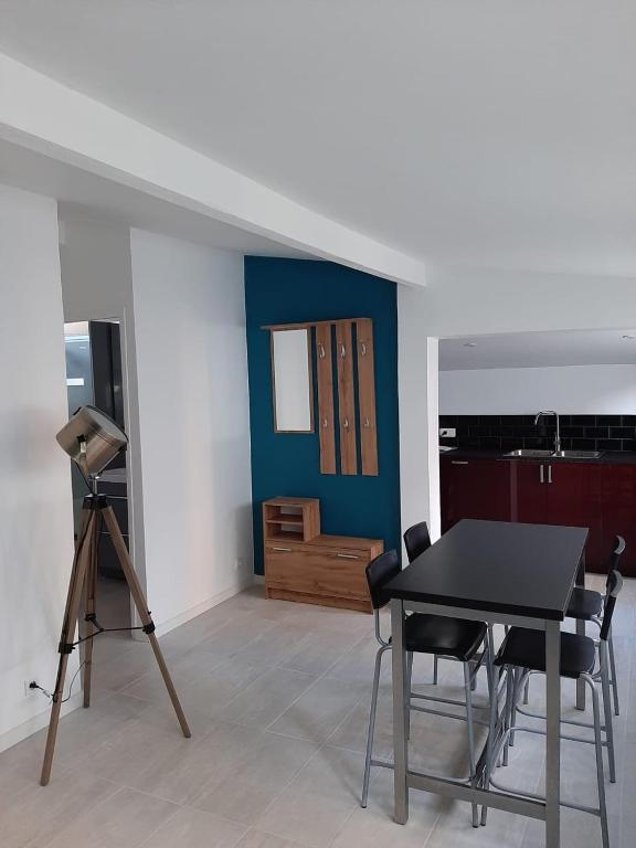 a room with a table and chairs and a blue wall at Le Cocon in Meudon
