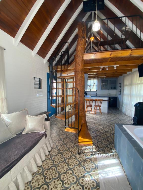 VideiraCabana Vale das Bromélias的客厅里有一张沙发和一个厨房