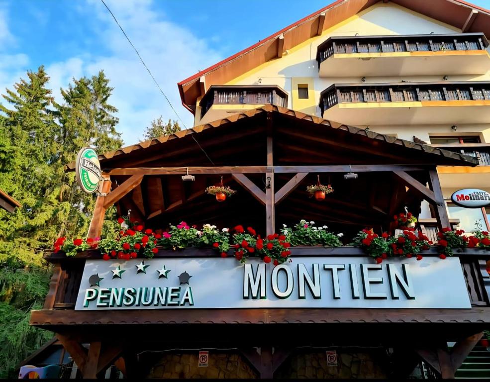a sign for a restaurant in front of a building at Pensiunea Montien in Predeal