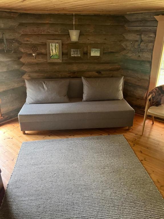 a bed in a room with a wooden wall at Villarkala in Heinola