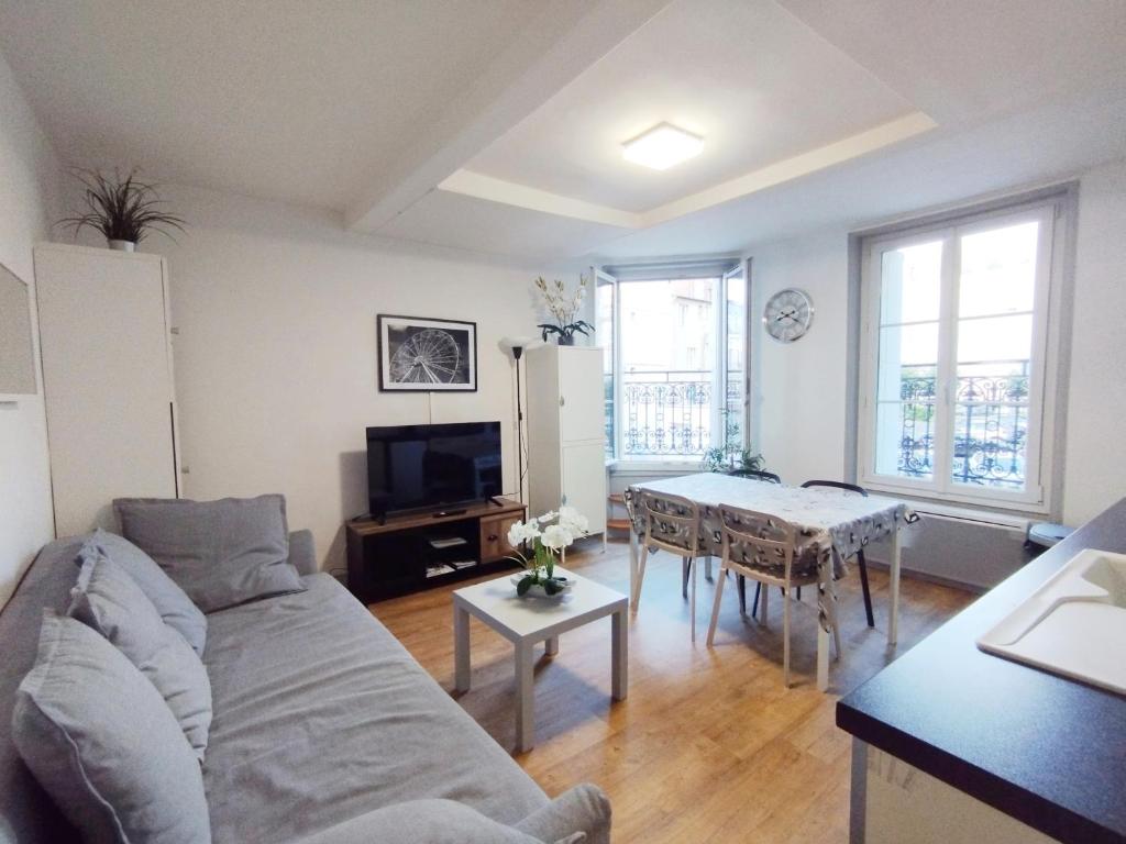 a living room with a couch and a table at Le Capitaine Jack in Trouville-sur-Mer