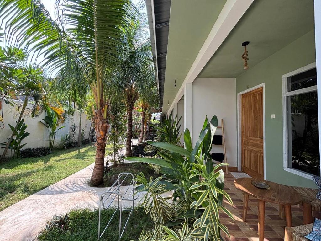 ギリ・アイルにあるPalm Trees Villasのヤシの木とテーブルと椅子のあるパティオ