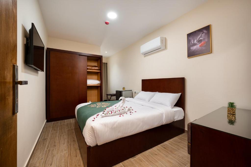 a bedroom with a bed and a television in it at Elyasmene in Qinā