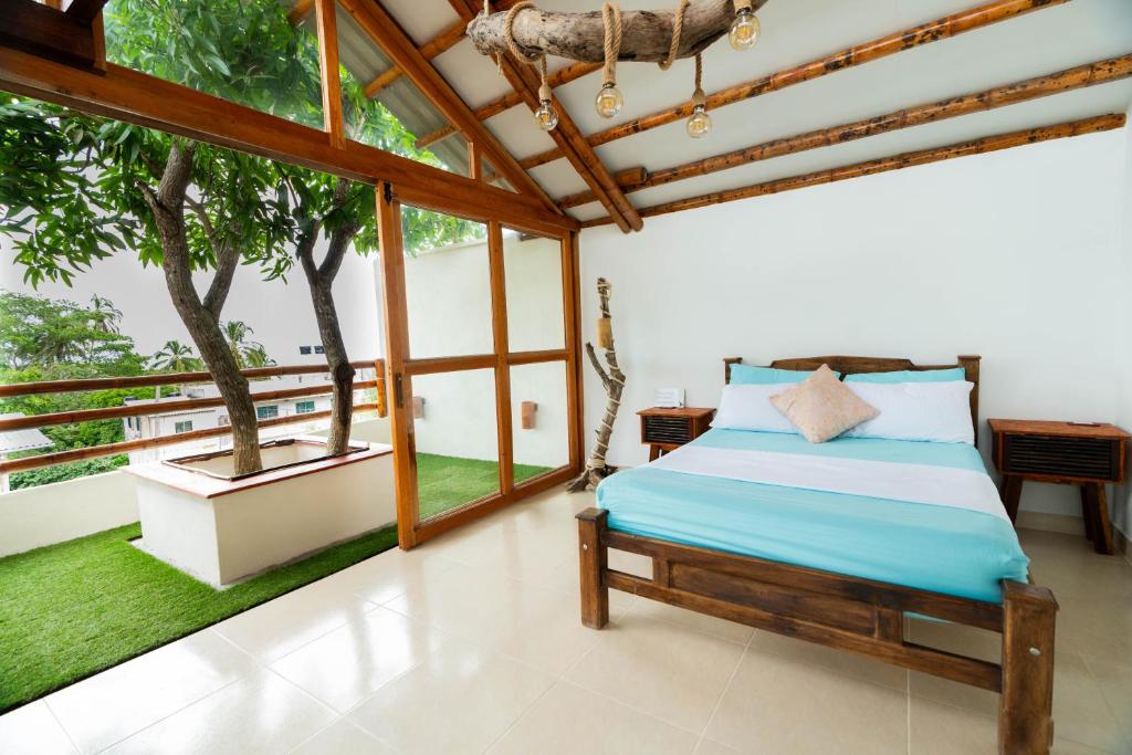 a bedroom with a bed in a room with windows at Tayrona JH Hostels in Los Naranjos