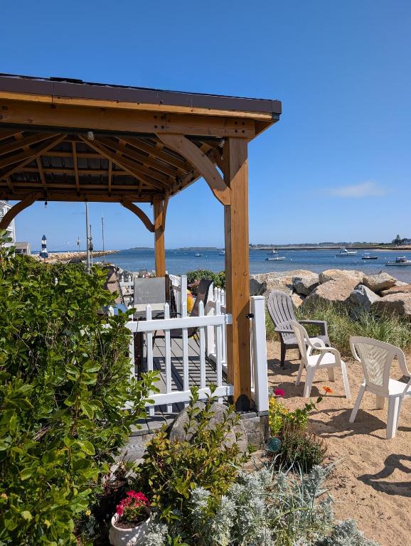 a gazebo on the beach with chairs and flowers at Beach Cottage in Saco