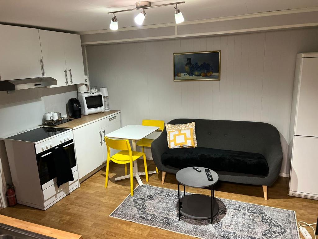 a living room with a couch and a table and a kitchen at 2 Bedroom Apartment Tiller in Trondheim