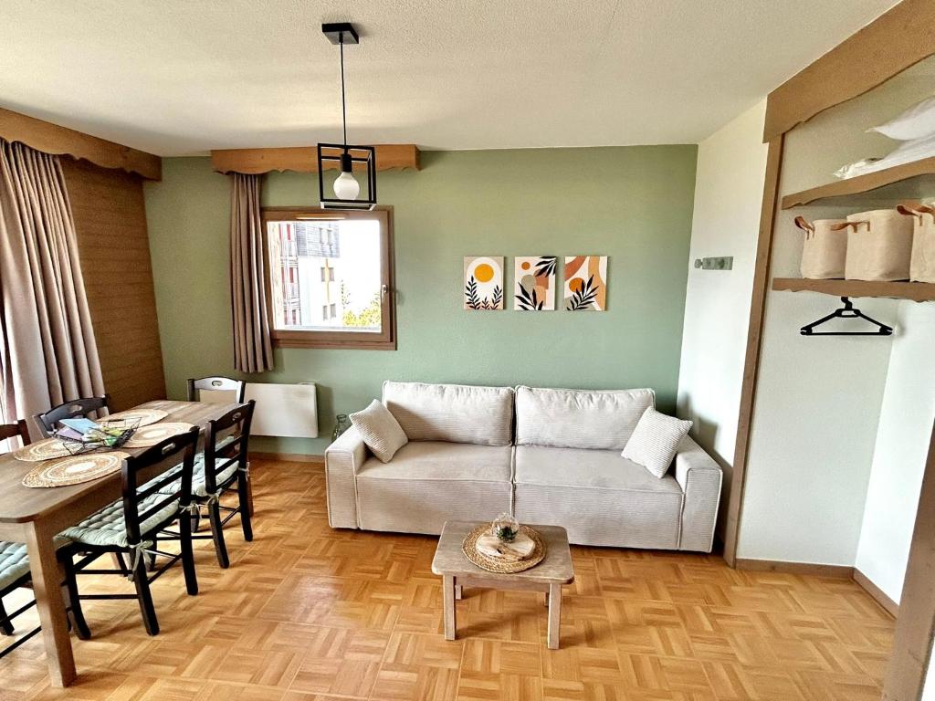 a living room with a couch and a table at Bel Appartement 6 personnes au pied des pistes in Chamrousse