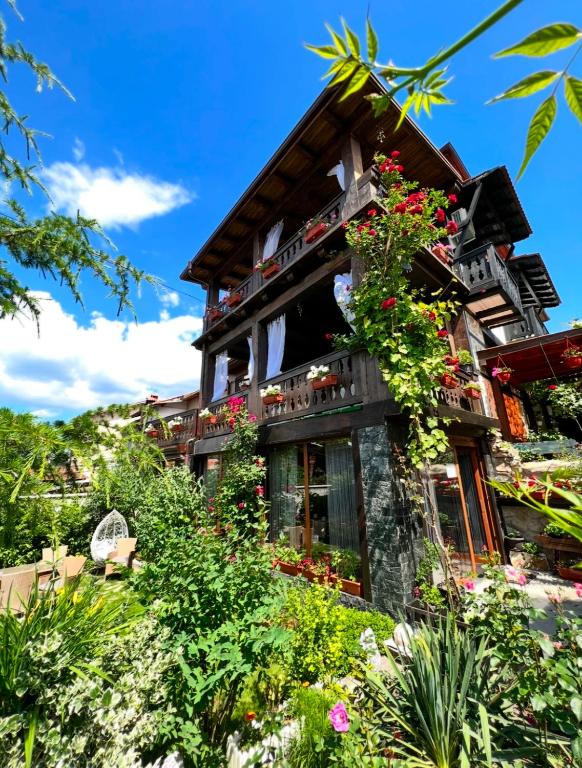 a house with flowers on the side of it at Oasis Guest House in Dobrinishte