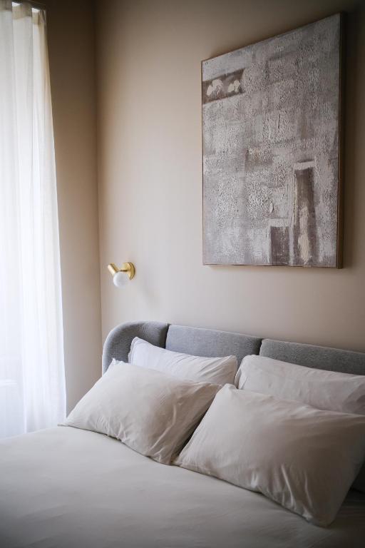 un lit avec des oreillers blancs assis à côté d'une fenêtre dans l'établissement Tower Studio Double Suite - Bernina Experience, à Tirano