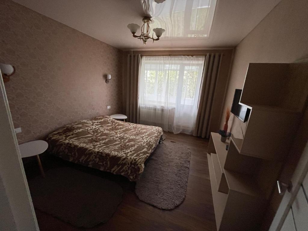 a small bedroom with a bed and a window at Apartamenty. Geroev Krut in Sumy