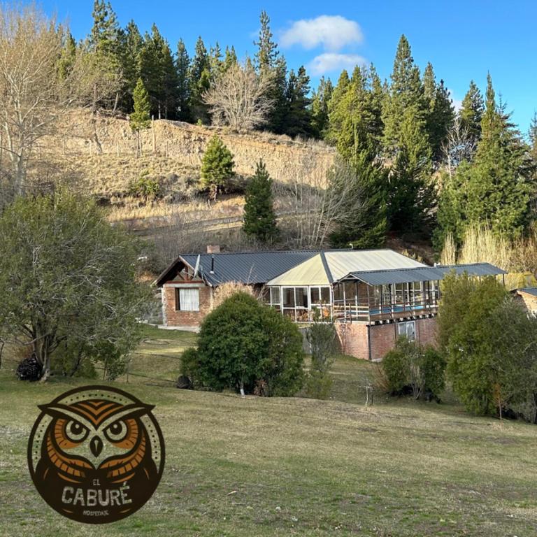 a house with an owl sign in front of it at el cabure casa de campo in Esquel