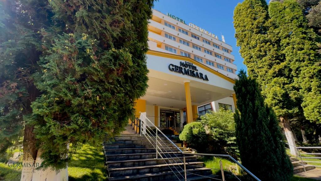 un edificio con scale e alberi di fronte di Hotel Germisara a Geoagiu Băi