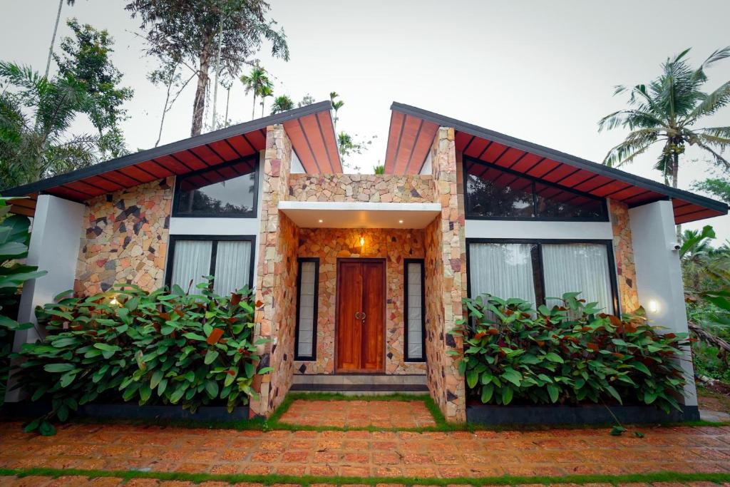 a house with a red door and some plants at wayanadjunglevillas in Kenichira