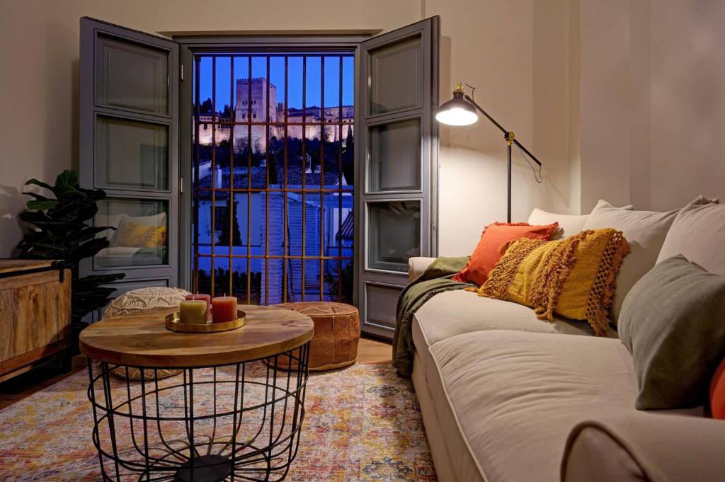 a living room with a couch and a table and a window at Luxury Alhambra Views Apartment in Granada