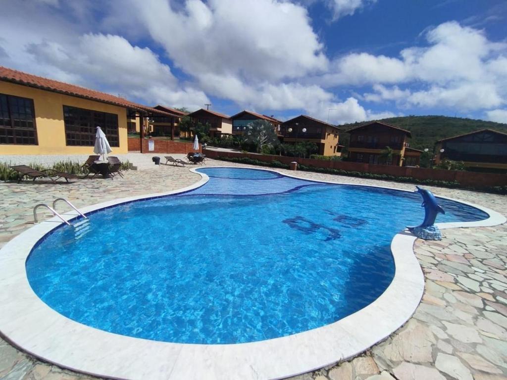 a swimming pool in a resort with a bird flying over it at Condomínio Alameda dos Pinheiros VI in Gravatá