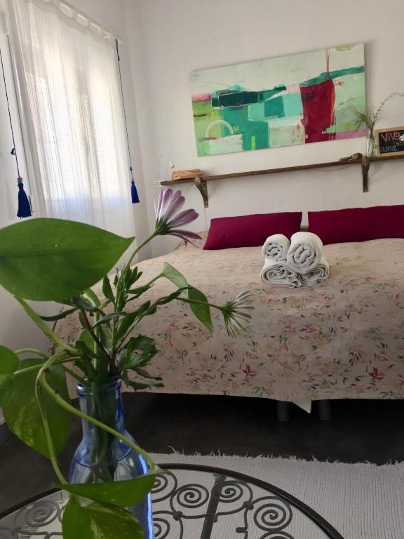 a bedroom with a bed and a vase with a plant at Casa Baraka in Algodonales