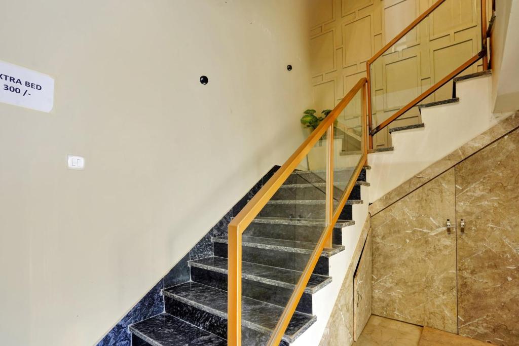 eine Treppe in einem Haus mit Holztüren in der Unterkunft HOTEL O STERLING 30 in Kota