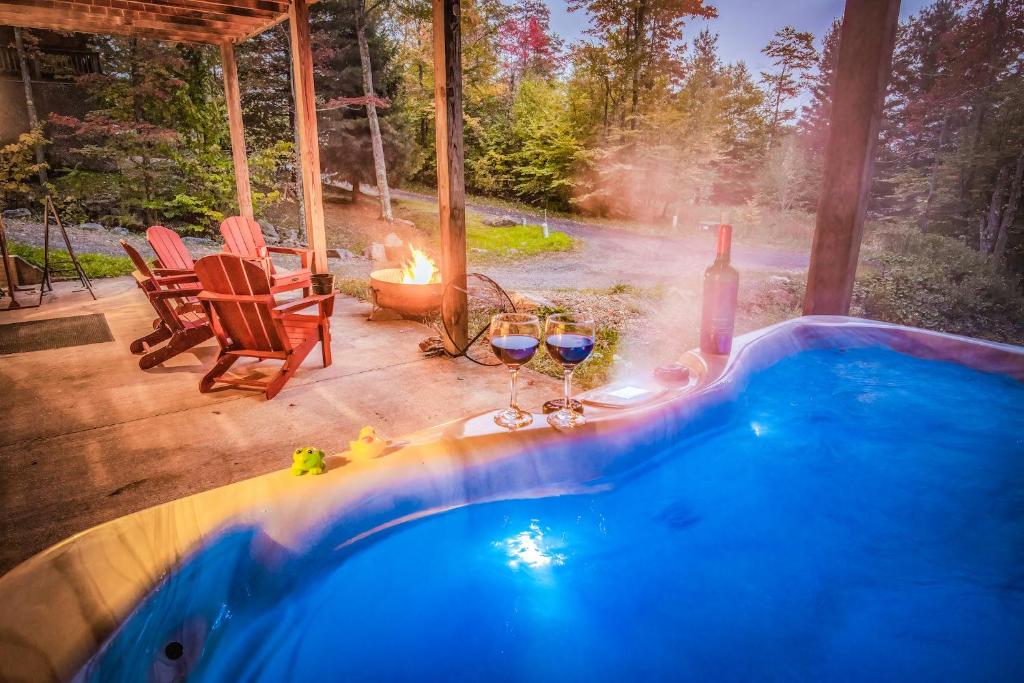 a swimming pool with two wine glasses and a fireplace at Leaf Peeper's - HUGE deck, pizza oven, Pac-man! in Davis