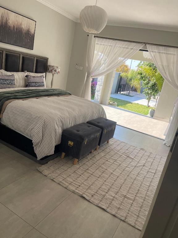 a bedroom with a large bed and a large window at Luna Holiday Home in Maun