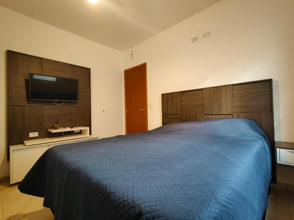 una camera da letto con un letto e una TV a schermo piatto di Casa de 3 quartos com ares-condicionados a Campo Grande