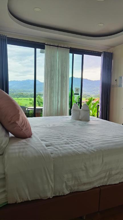 浦阿นะลาวิว รีสอร์ท ปัว Nala View Resort Pua的卧室设有一张大白色的床和大窗户
