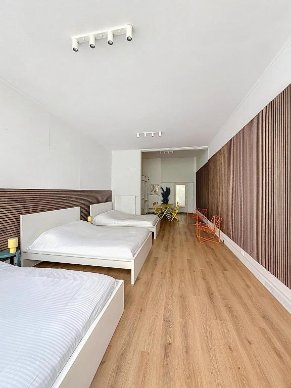 1 dormitorio con 3 camas y pared de madera en Central Spot - Louise, en Bruselas
