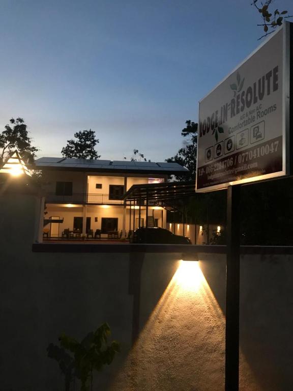 a sign in front of a house at night at Lodge in Resolute in Dambulla