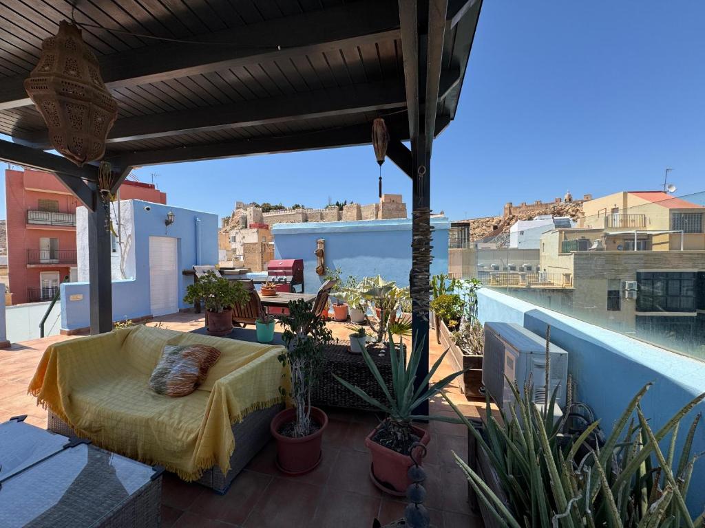 Un balcón con una cama y plantas en el techo. en La Pita Guesthouse, en Almería