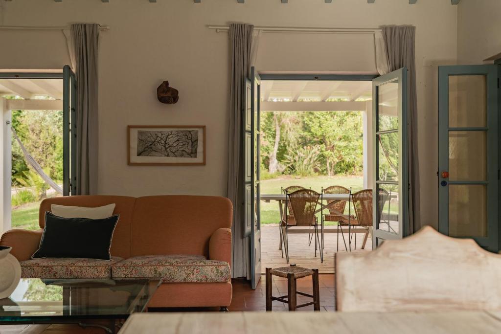 a living room with a couch and sliding glass doors at CABRA - Porto Covo in Porto Covo