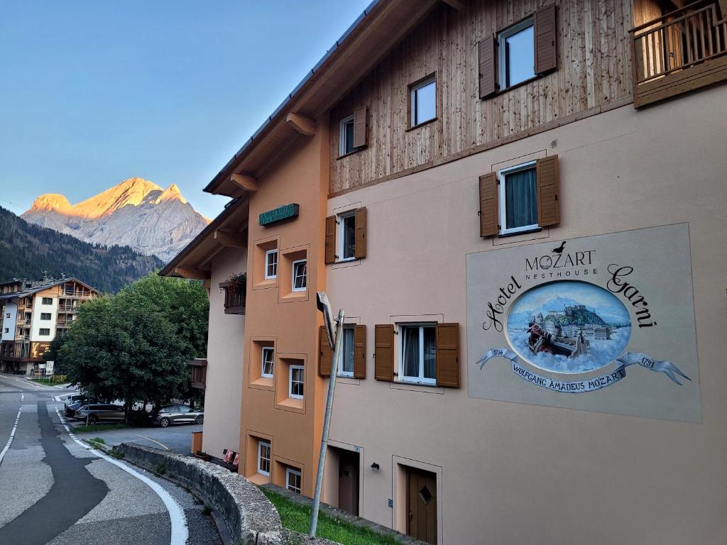 a building with a sign on the side of it at Garni B&B Mozart Nesthouse in Canazei